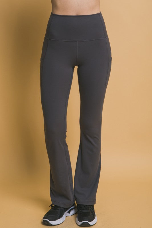 Woman wearing dark gray high-waist flare yoga leggings, designed for comfort, flexibility, and modern activewear style.